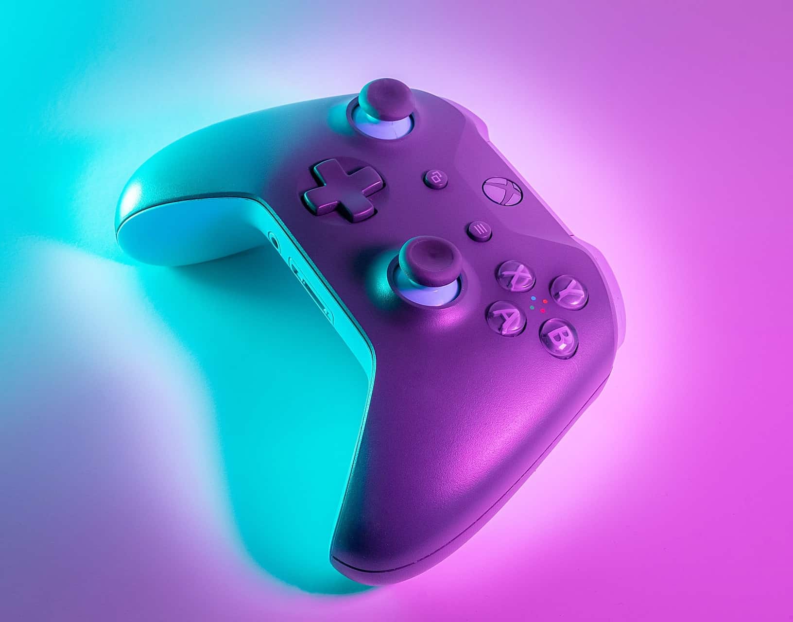 Hot Pink and Cyan colored Xbox controller laying down