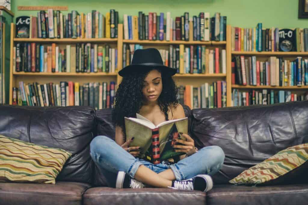 Young Black Woman reading a book as a sensitivity reader
